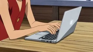 Luffy programming on a Macbook in the Thousand Sunny